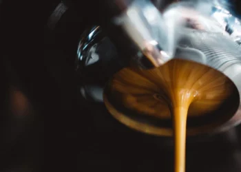 Perfect espresso extraction flowing from portafilter into cup