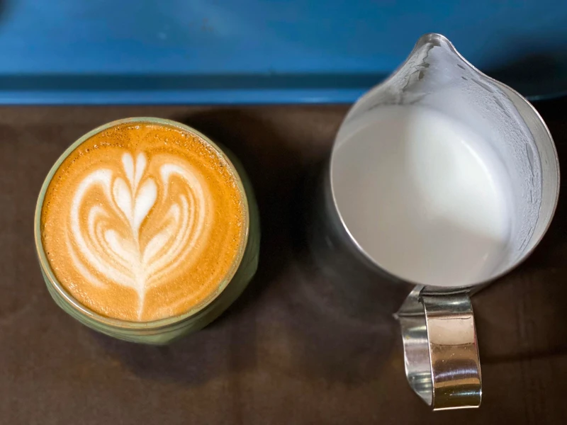 Perfect microfoam texture in milk pitcher showing glossy surface